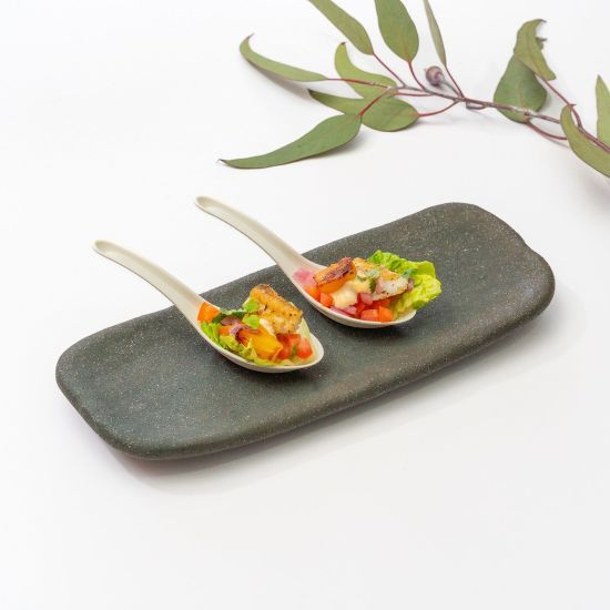 Canapés plated on ceramic spoons with native garnish
