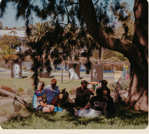 Guests gathered under a tree at Footscray Community Arts